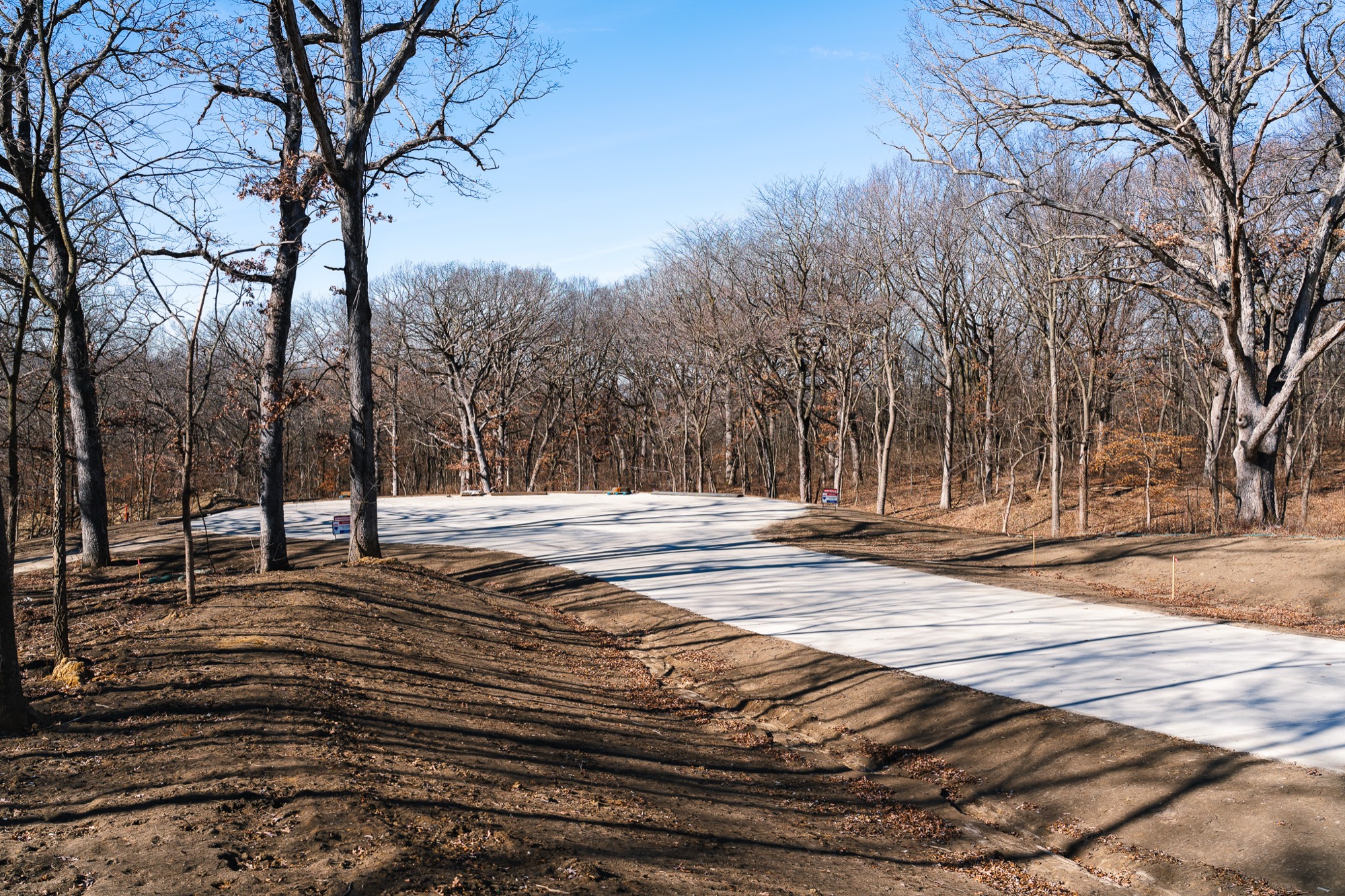 The paved entrance road into Summerset Estates running into the timber